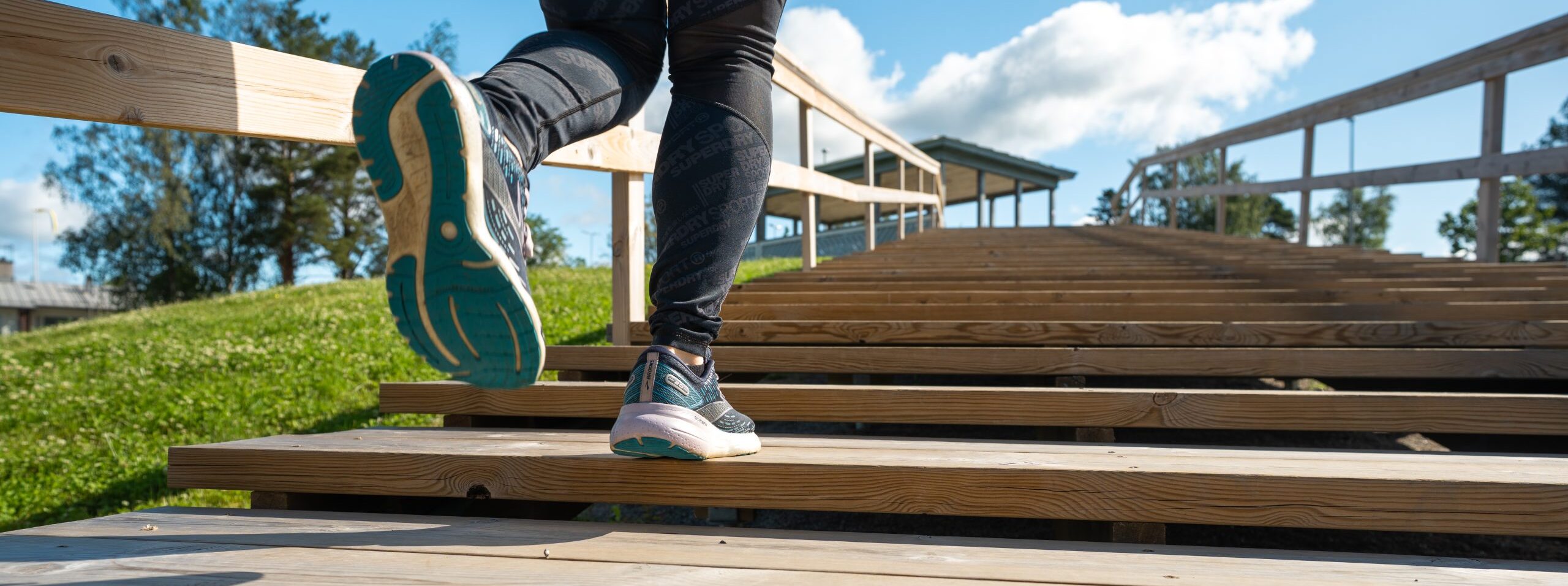 A close-up of a runner's legs climbing the fitness stairs.
