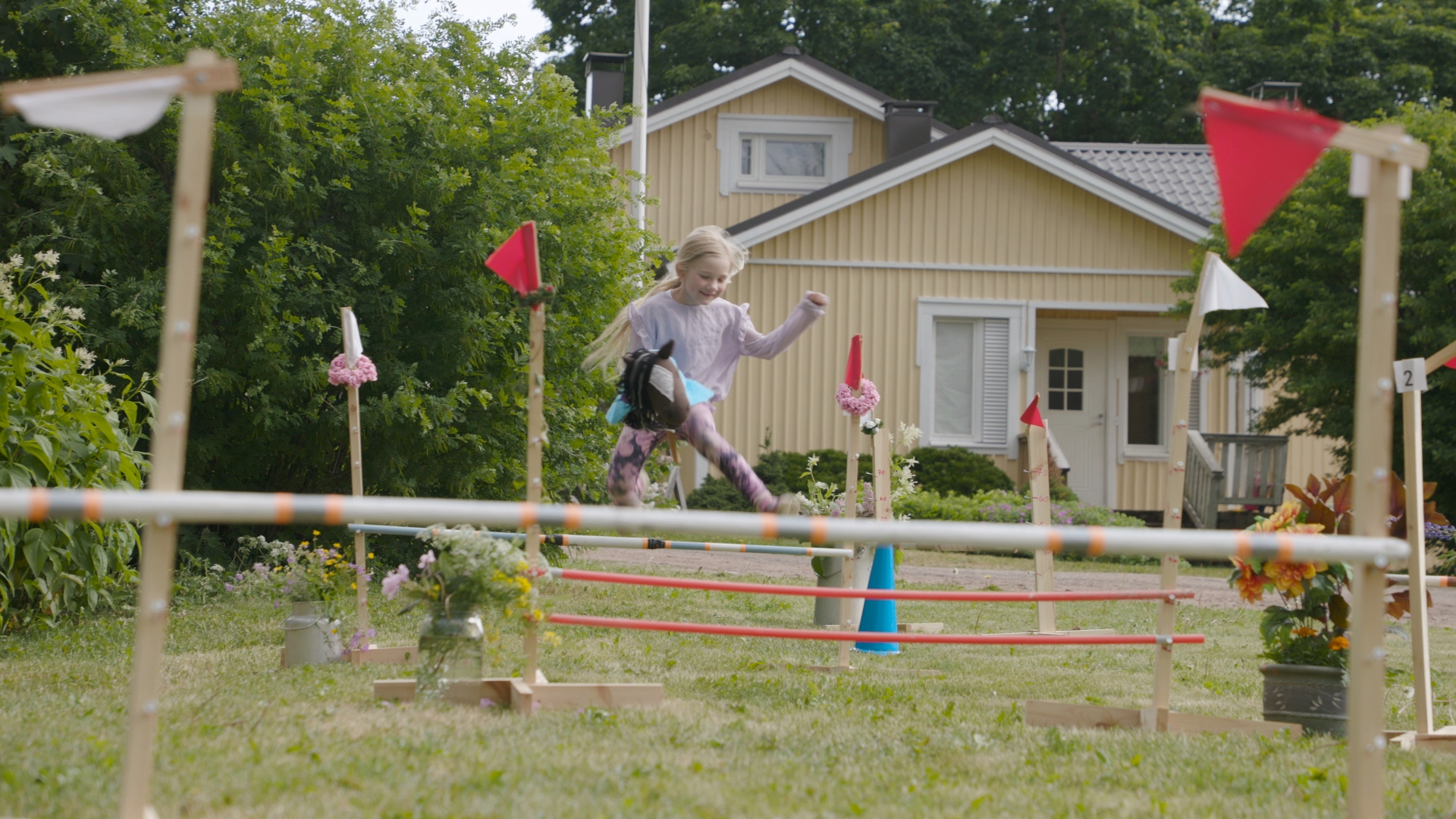 Tyttö keppihevosradalla.