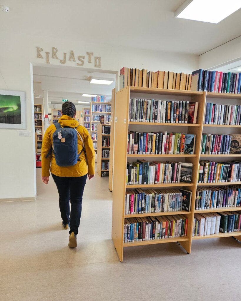 Henkilö kävelemässä kirjaston käytävää pitkin menossa kohti tutkijanhuonetta